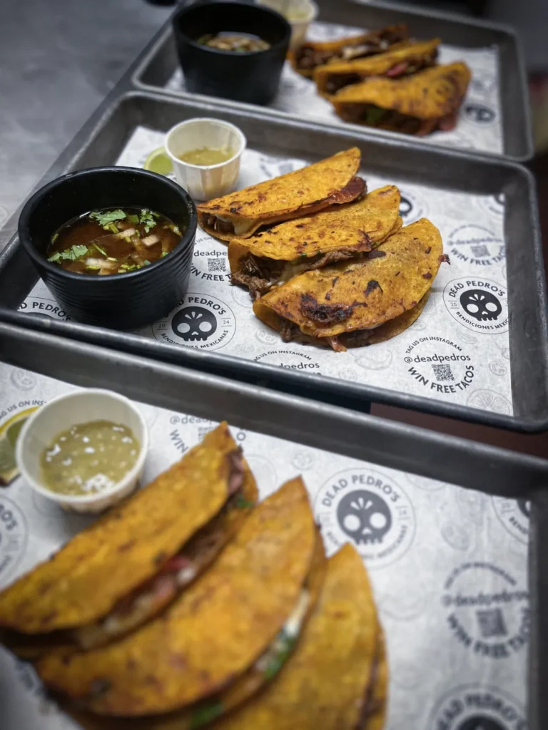 Beef birria tacos served with consomé and salsa verde